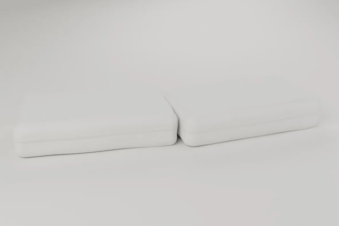 Two foam pillows side by side on a pale studio ground. Rendering, not a photograph of shipped goods.